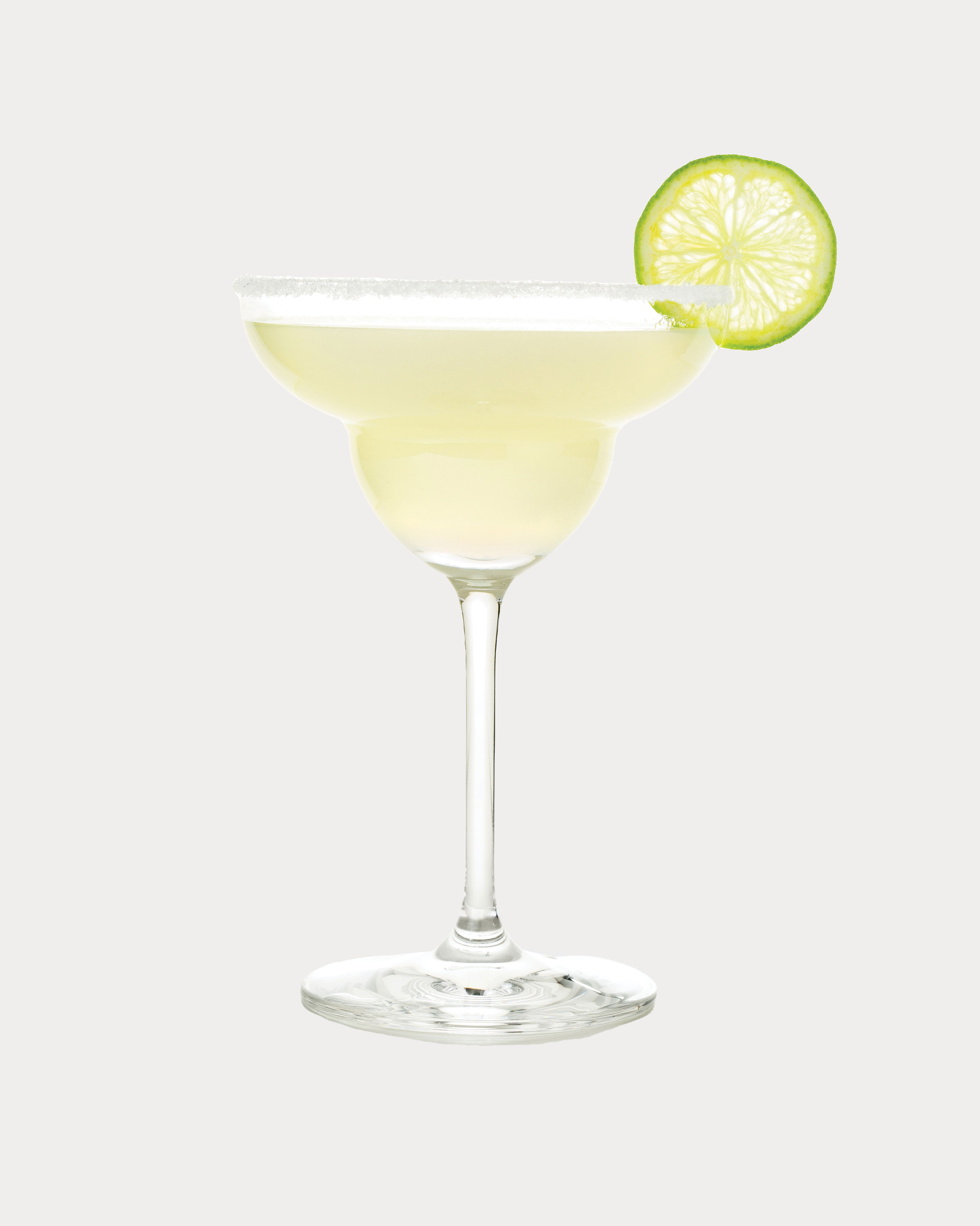 A margarita cocktail in a wide-rimmed glass with a salted rim and a lime wheel garnish.