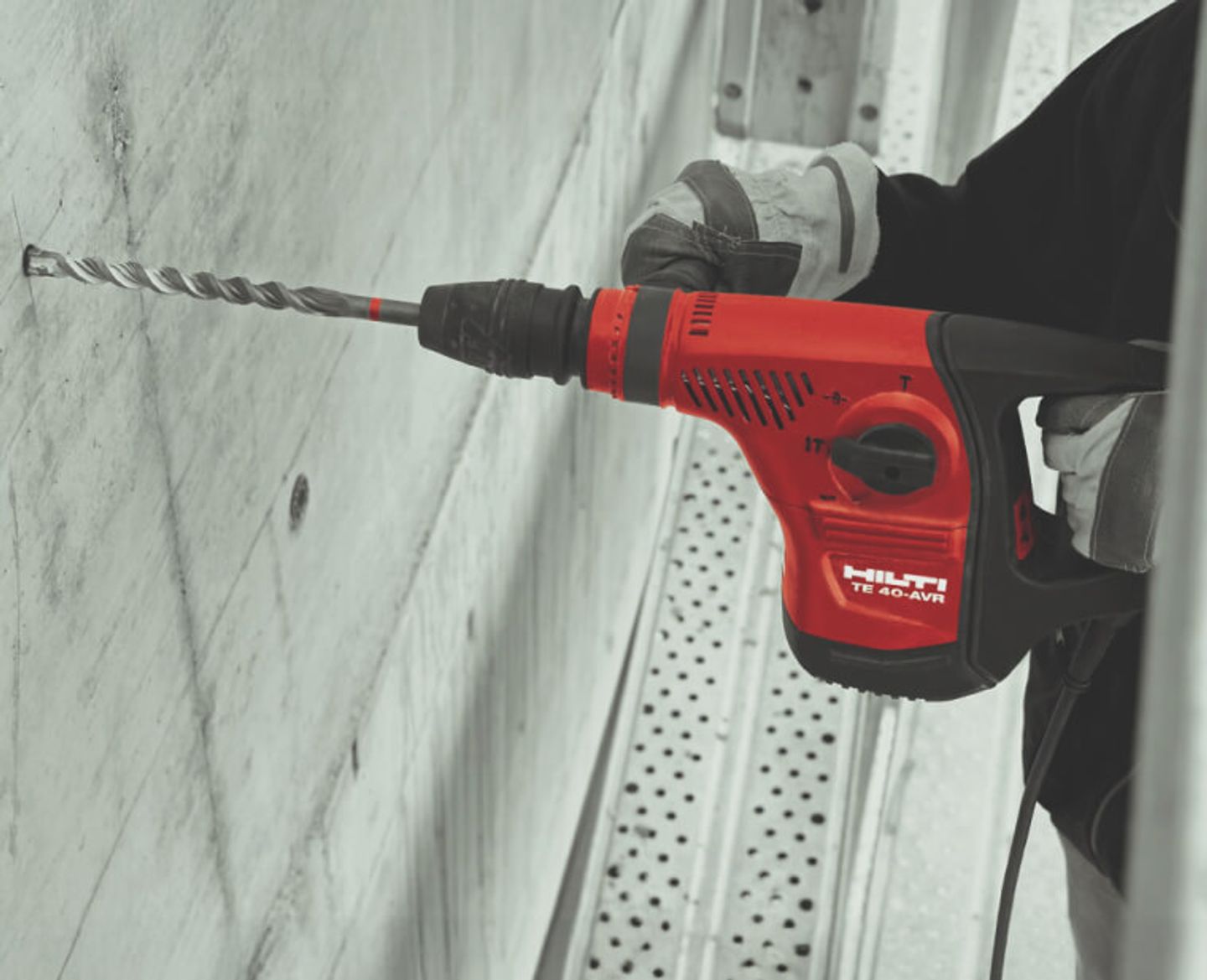 Someone using a Hilti drill in a concrete wall.