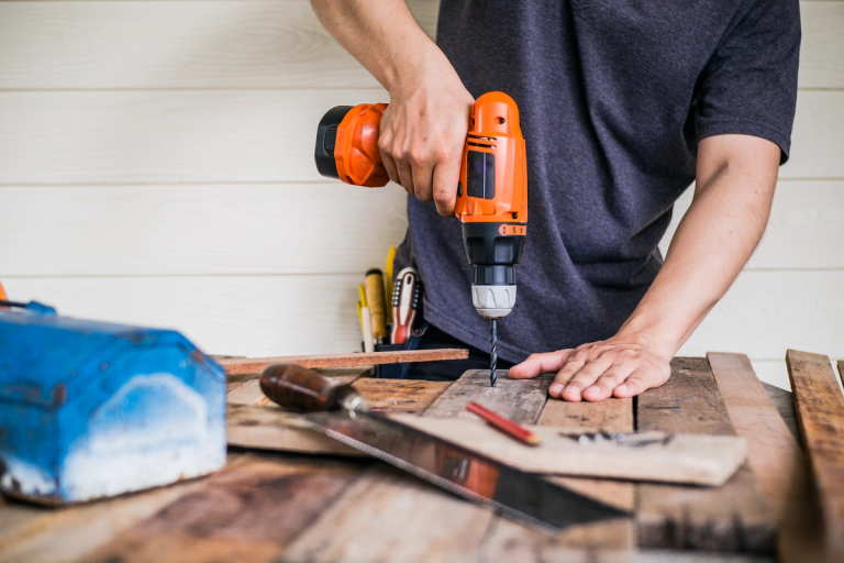 person drilling the wooden board
