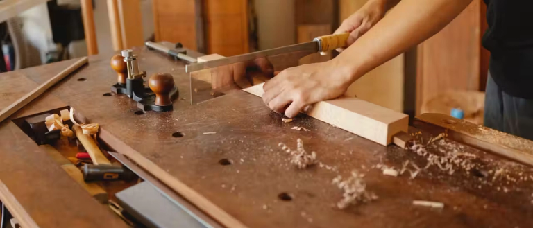 Someone using a handsaw on a piece of wood
