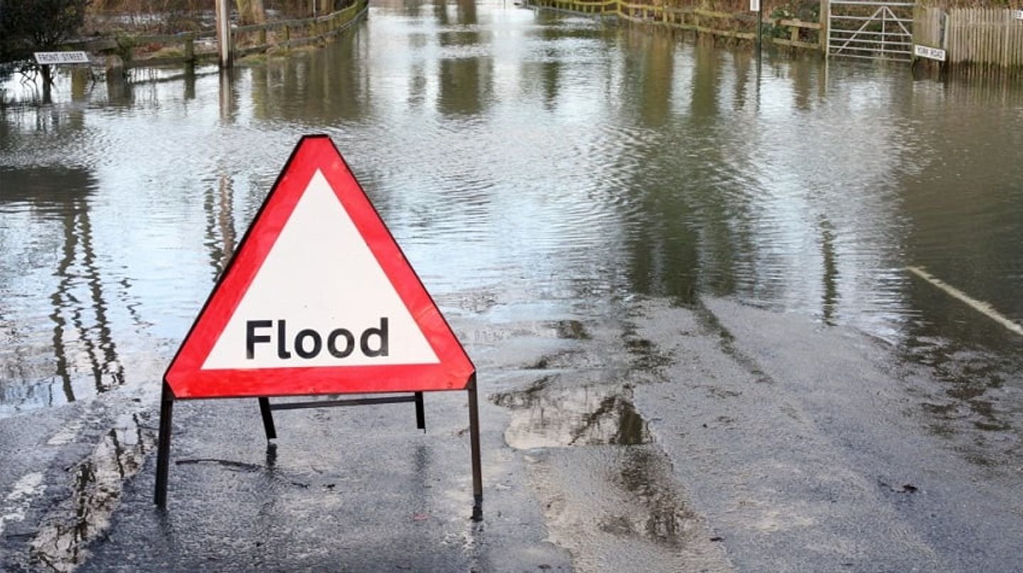a flood road sign in the middle of the flooded road