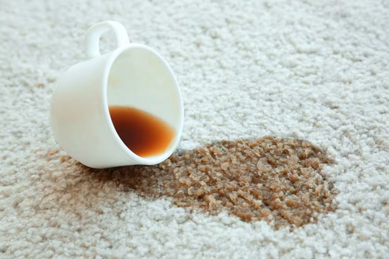 A spilled coffee mug on a cream carpet.