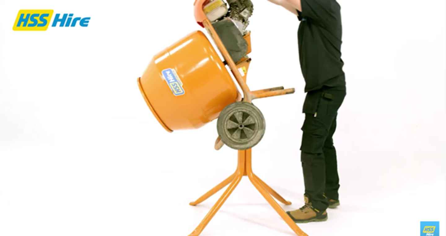Man connecting and positioning the concrete mixer drum