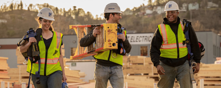 group of people carrying werner ladder on site