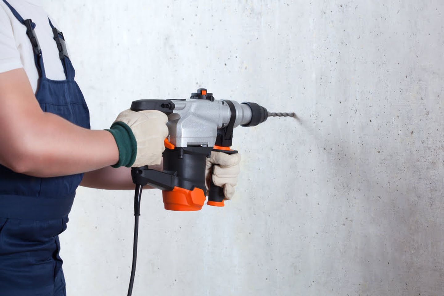 hammer drilling the concrete wall
