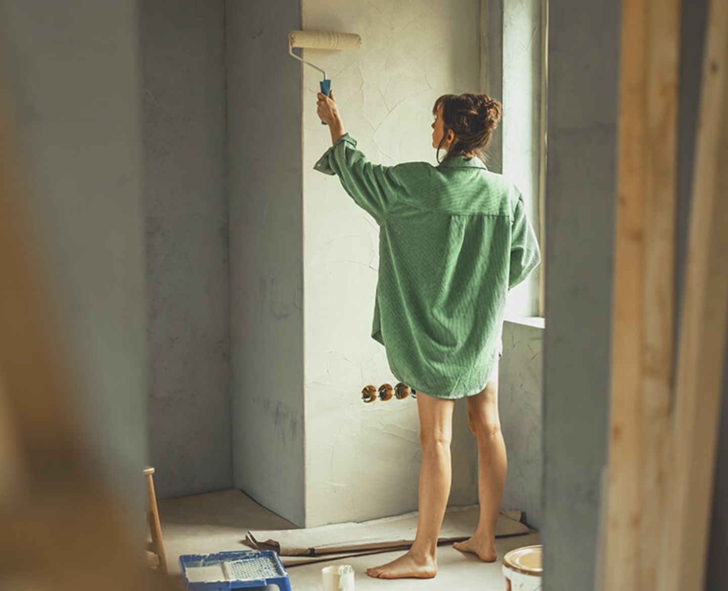 Decorator smoothing a fresh length of wallpaper onto the wall
