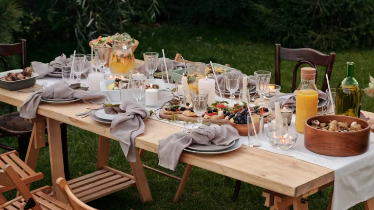 A garden table decorated with plates, food and drinks.