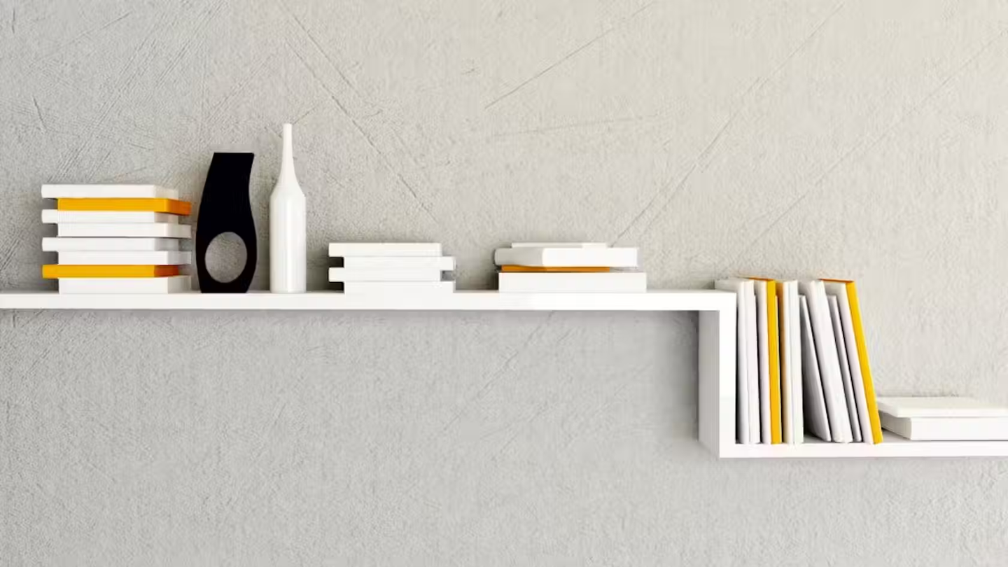 White shelves with several books and ornament on top.
