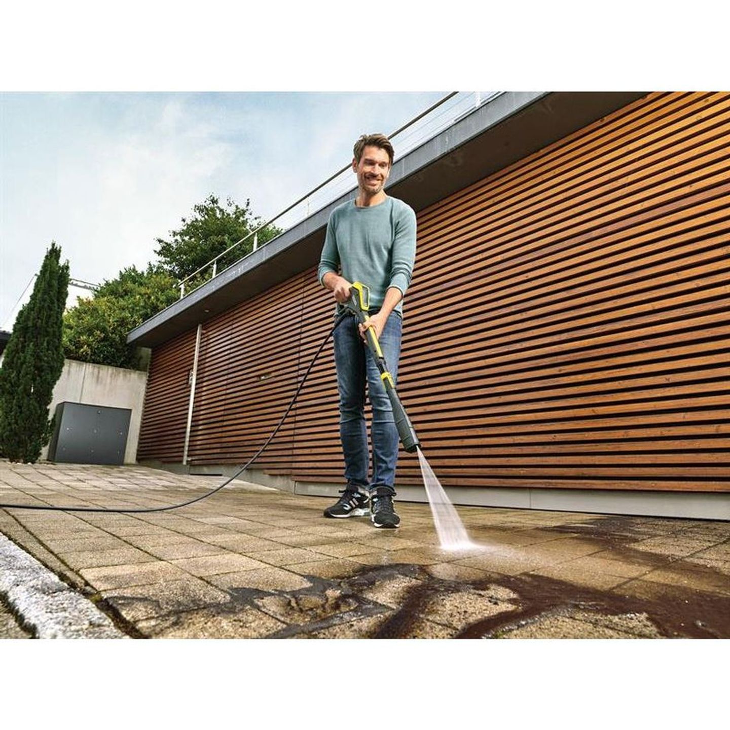 man cleaning paving with a pressure washer
