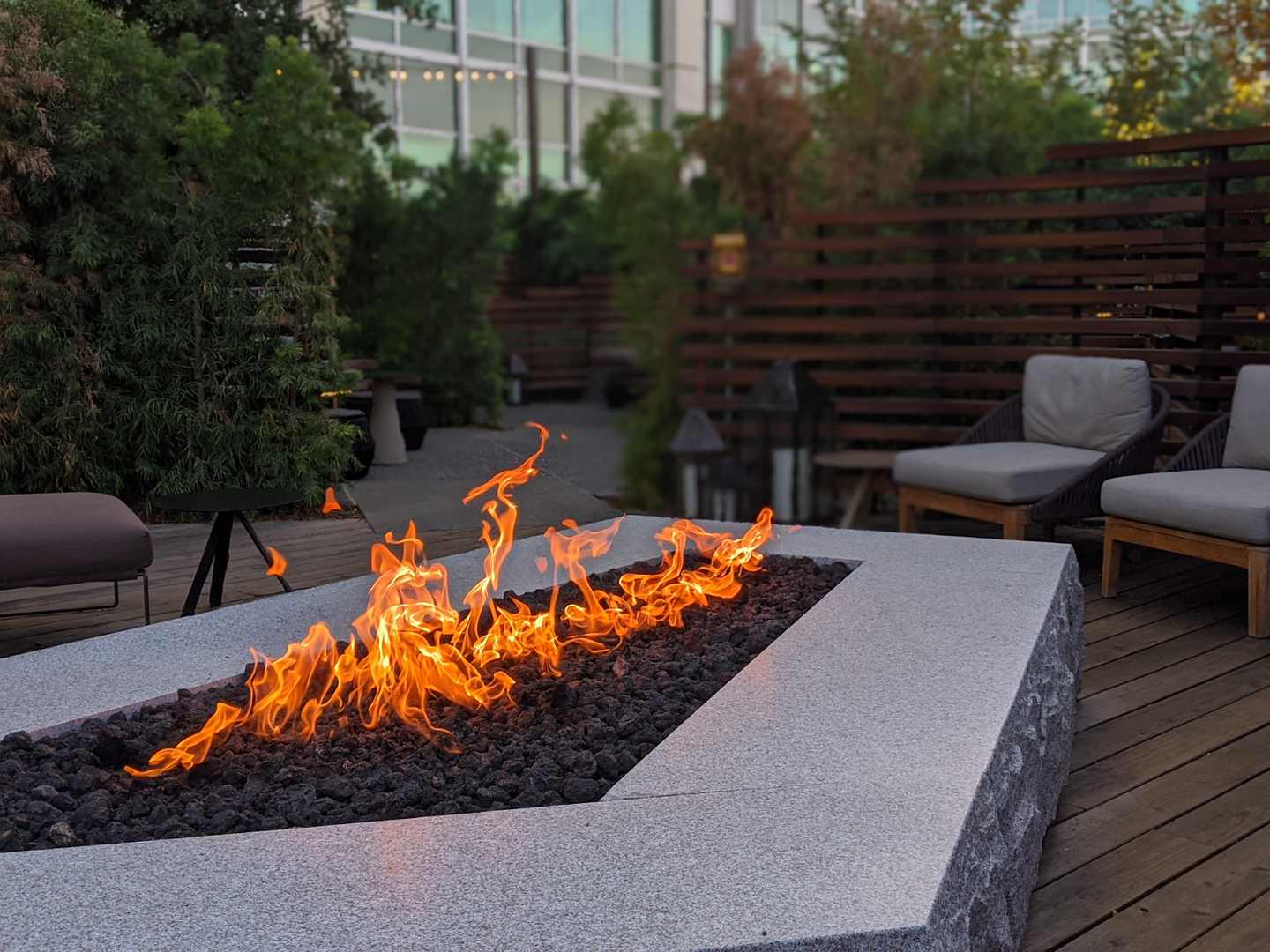 a modern garden firepit and cozy minimalistic modern furniture on a garden patio