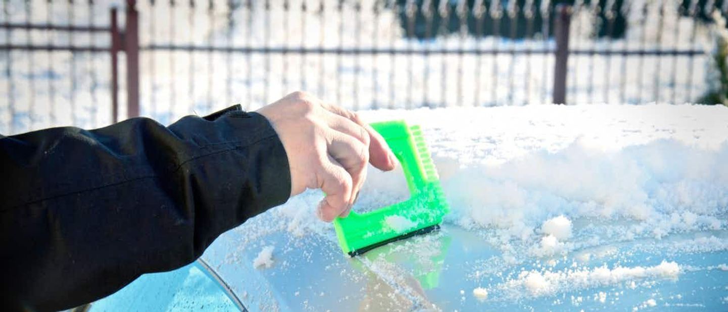 scraping snow off the car