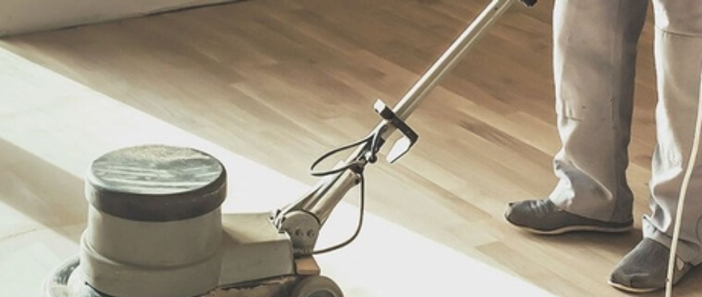 man sanding the floor using floor sander