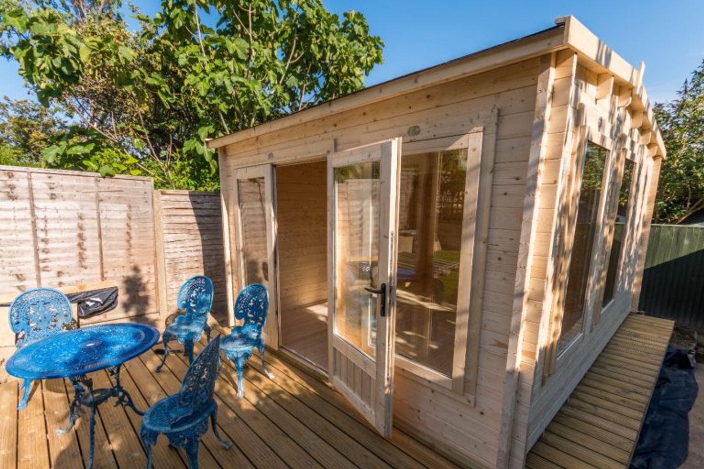 a plain wood garden shed patio and the blue cast iron furniture