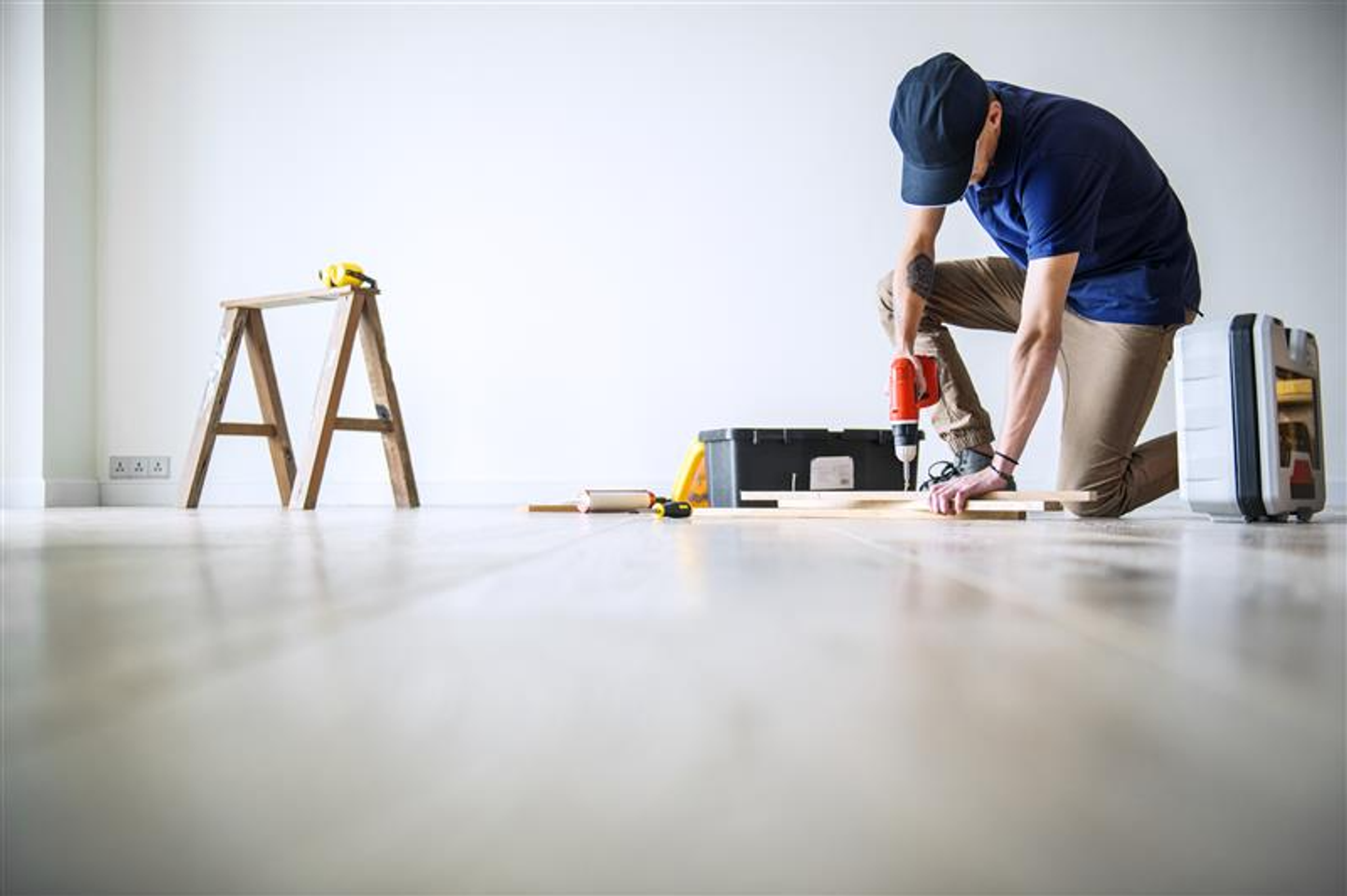 A man drilling holes into piece of wood.