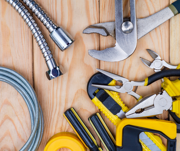 set of plumbing tools on the plain wood background
