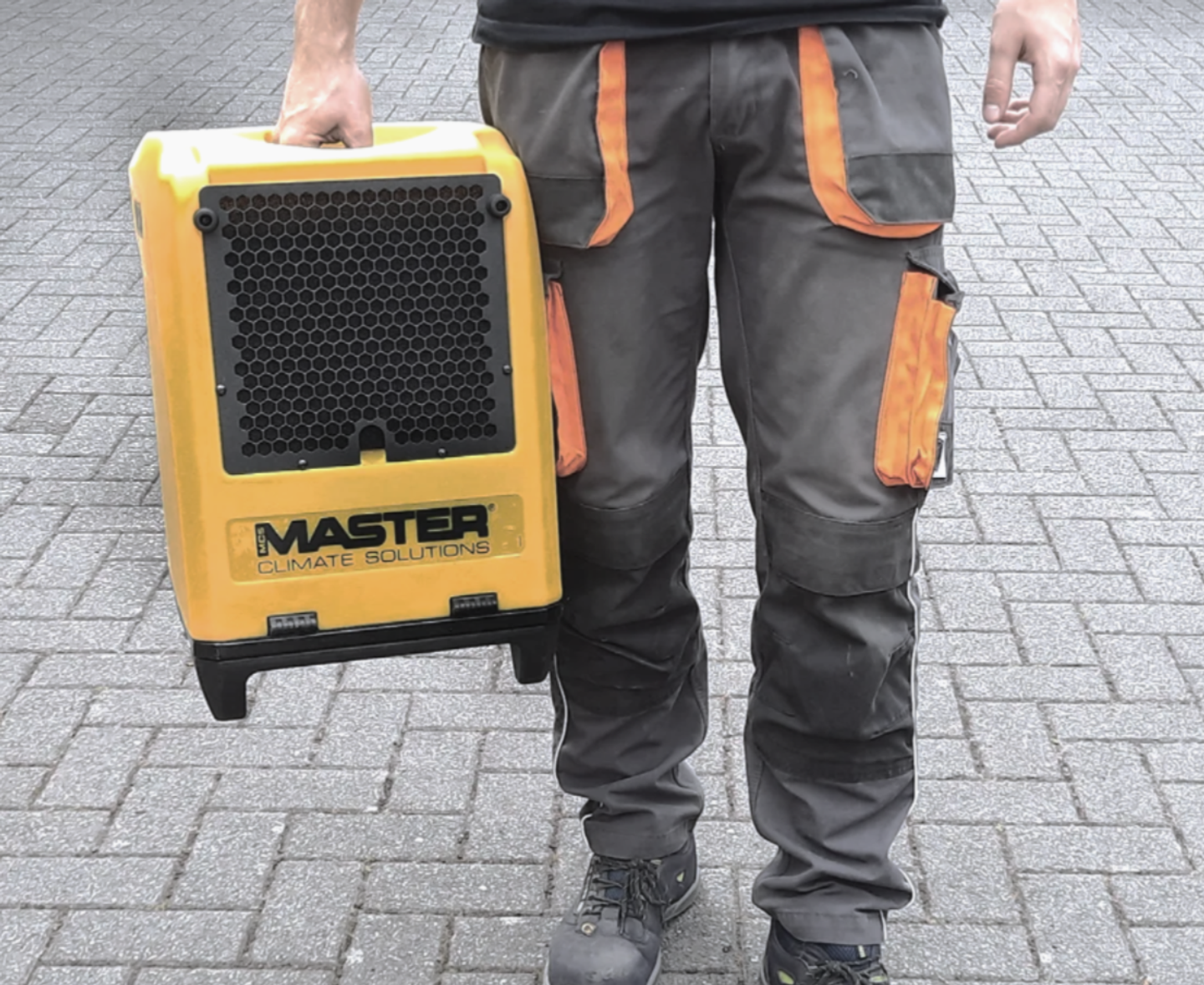 Portable building dryer dehumidifier being carried to a drying job