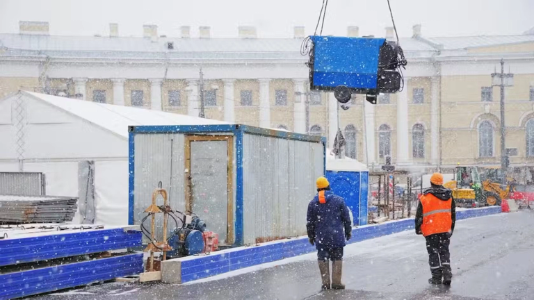 Construction workers stood on site on a snowy, winters day.