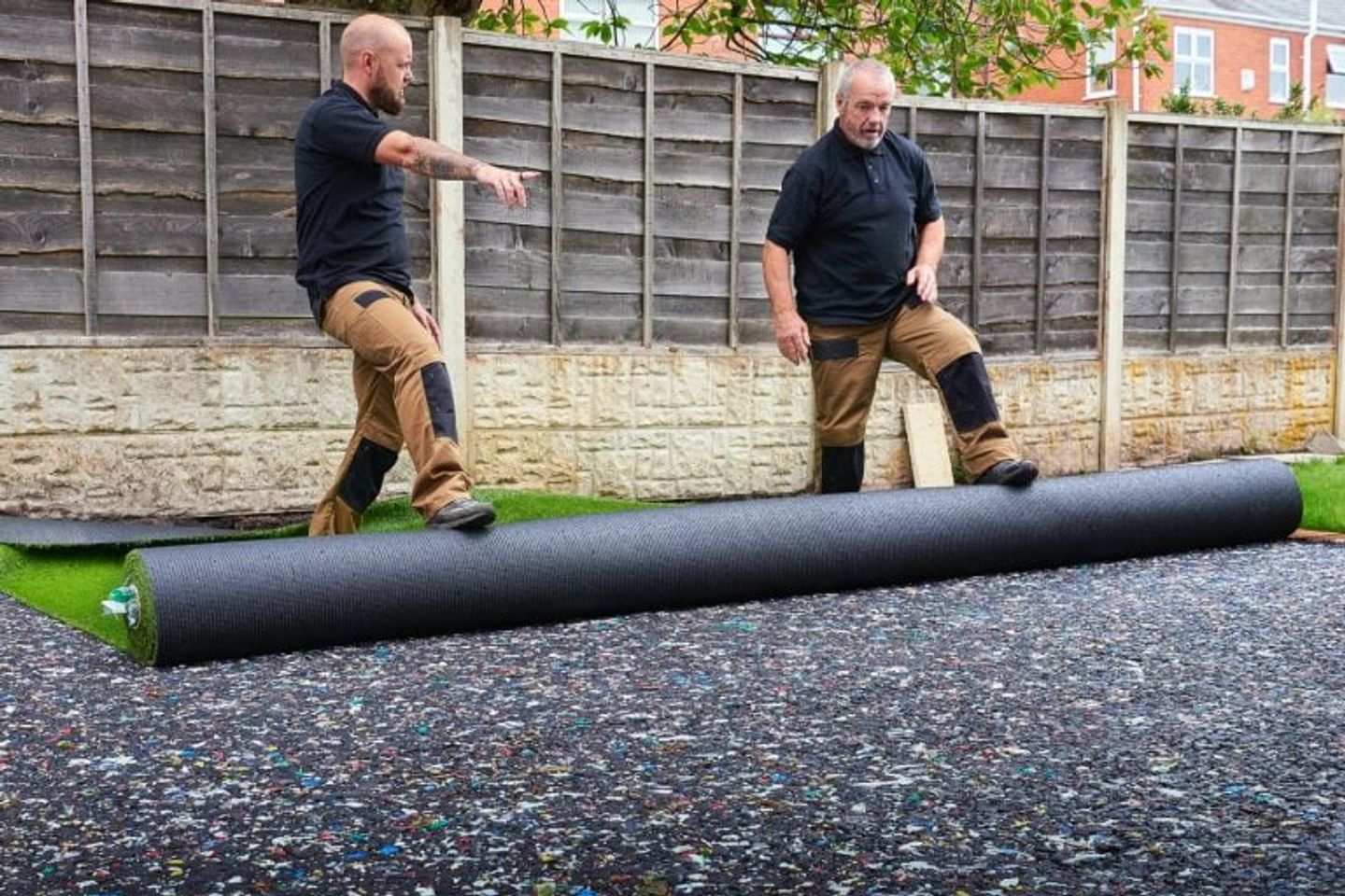two man unrolling artificial grass