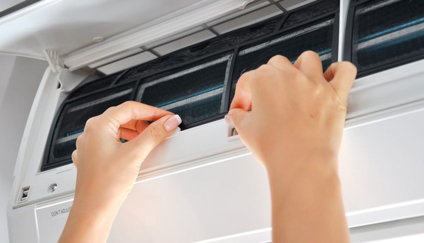 Hands troubleshooting the air conditioning unit that stopped working