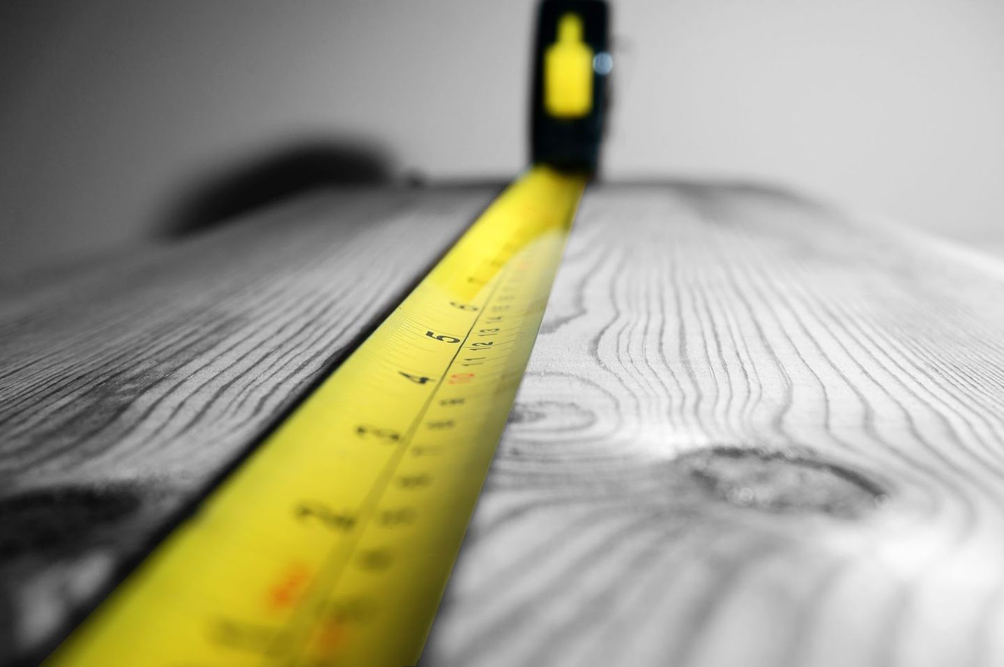 yellow measuring tape on a black and white wood
