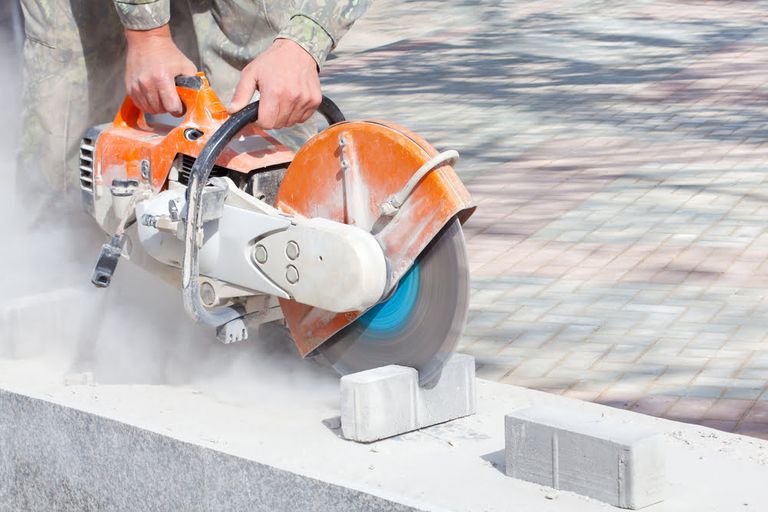men using diamond blade saw to cut concrete blocks