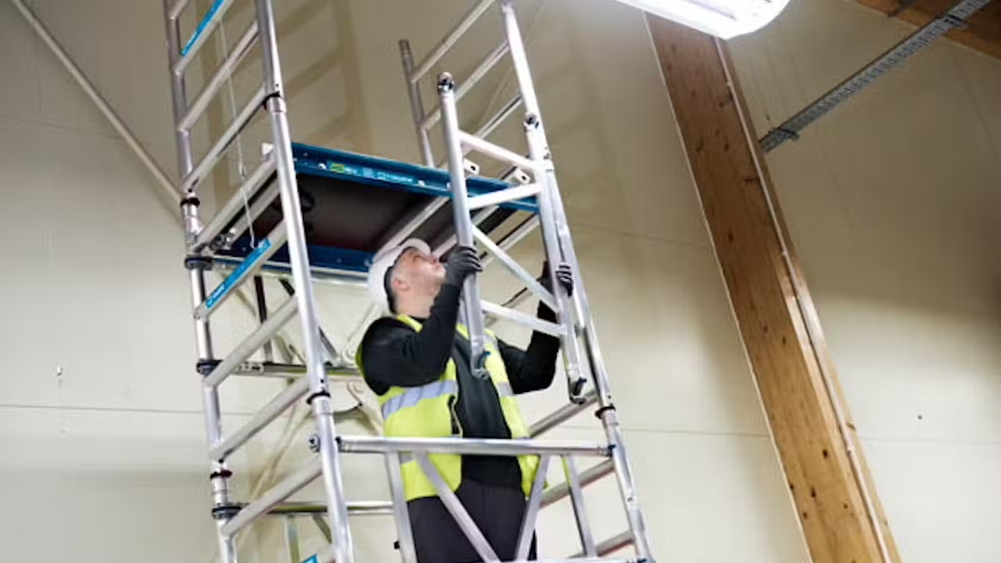 Site worker assembling an access tower