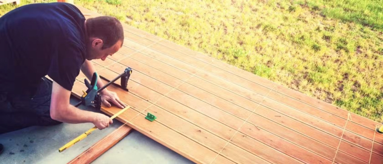 A man measuring wood for decking.