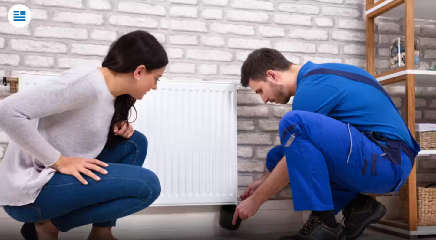 A gas engineer bleeding a radiator.