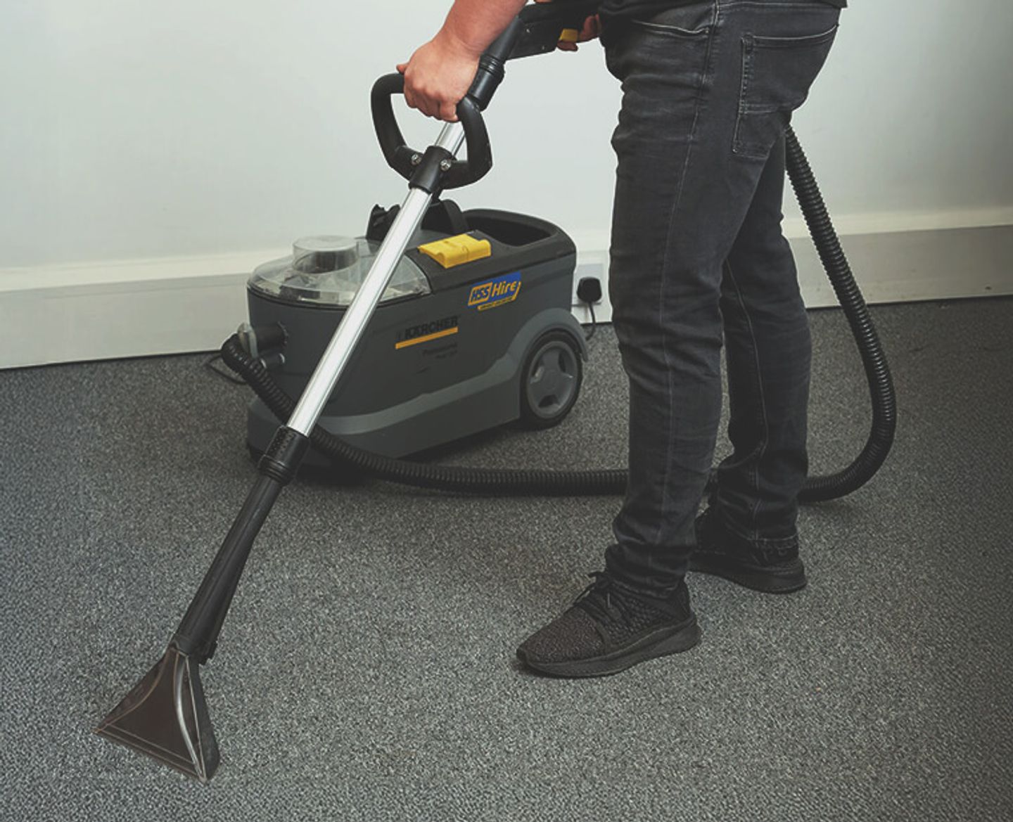 Someone using a carpet cleaner.