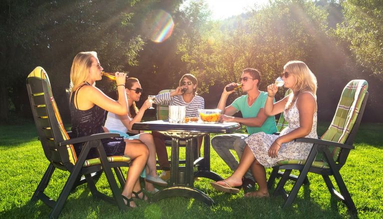 people sitting outside in the sunny garden during an outdoor event
