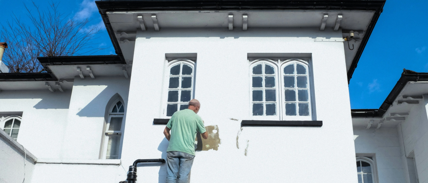 man painting external house wall