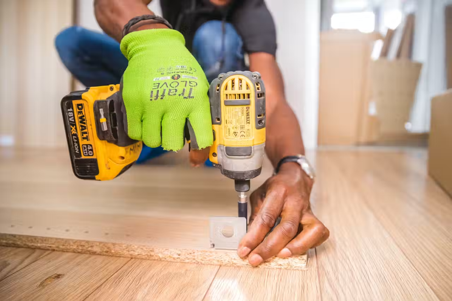 A cordless drill being used on a plank of wood.