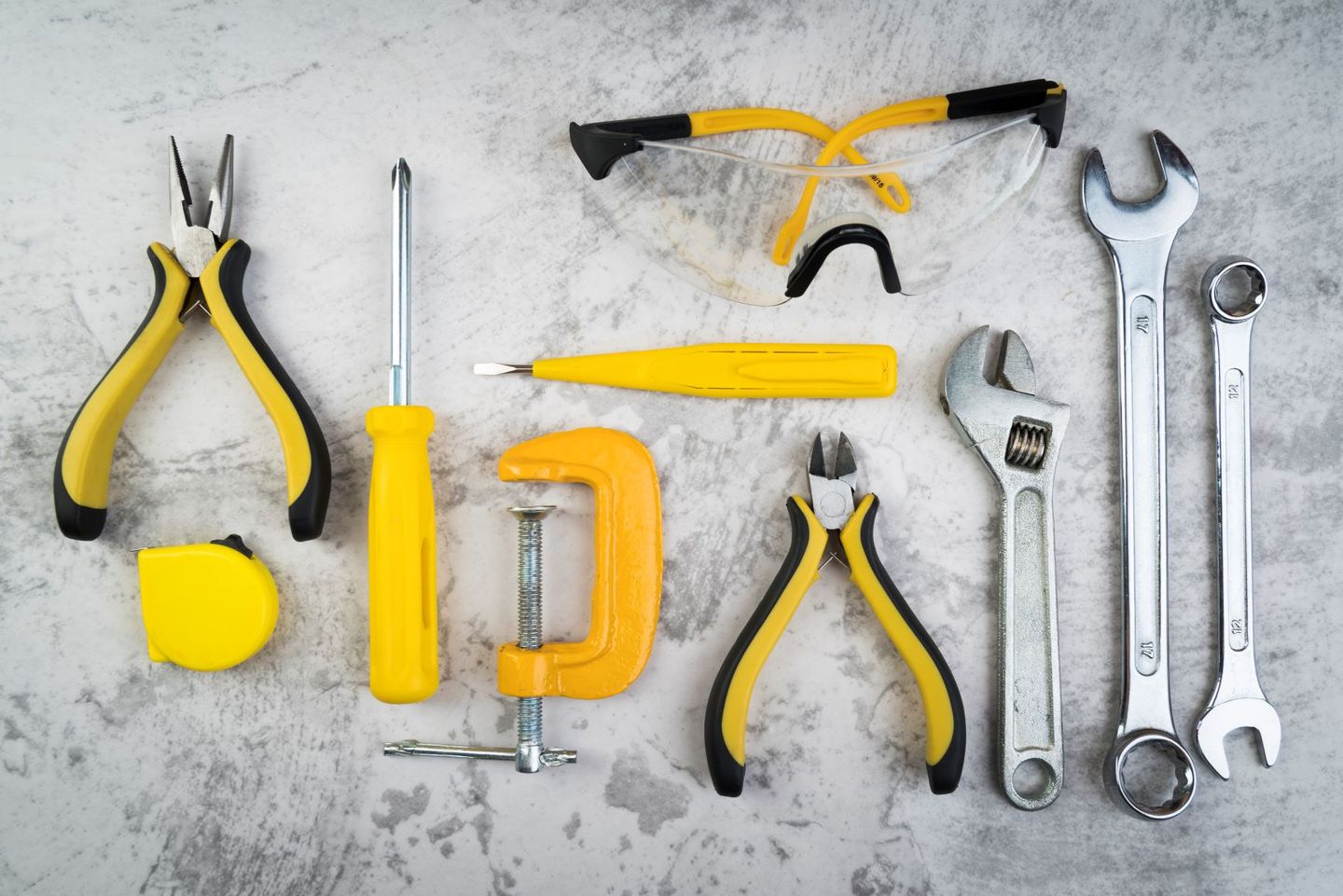Overhead view of a selection of hand tools including pliers screwdriver and spanners