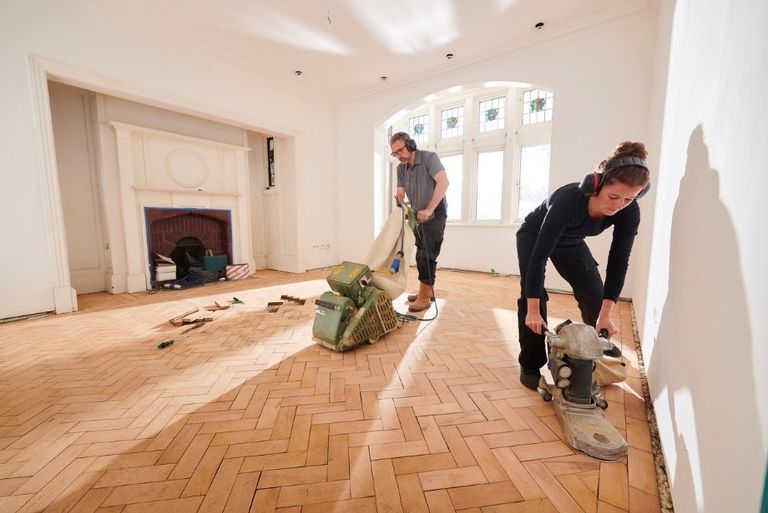 couple sanding the floor