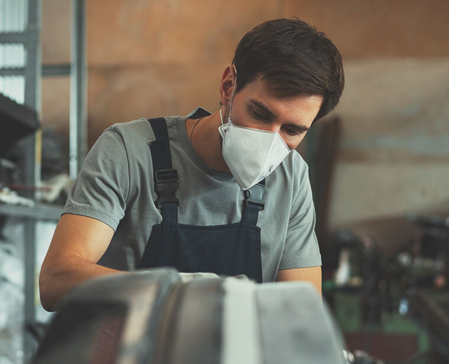 Wearing a disposable filtering facepiece dust mask while working in a dusty workshop