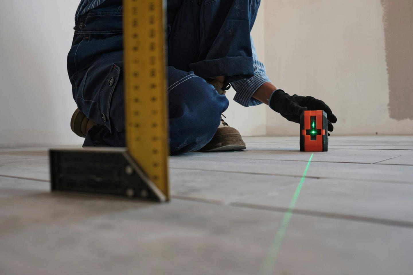 Laser level being used on a wooden floor.