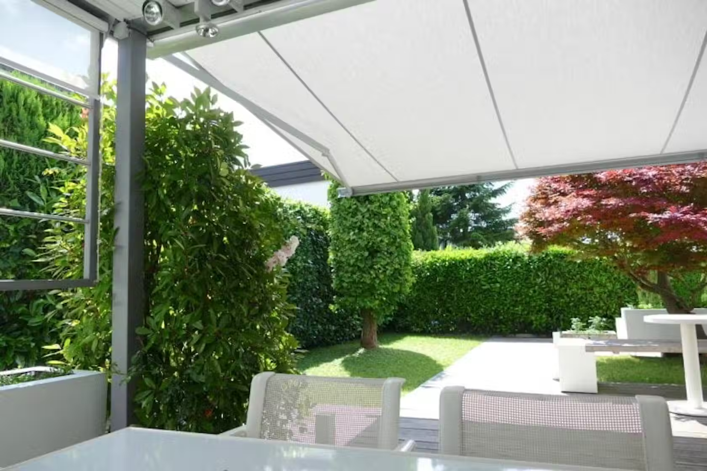 Garden table and chairs covered by a retractable canopy.