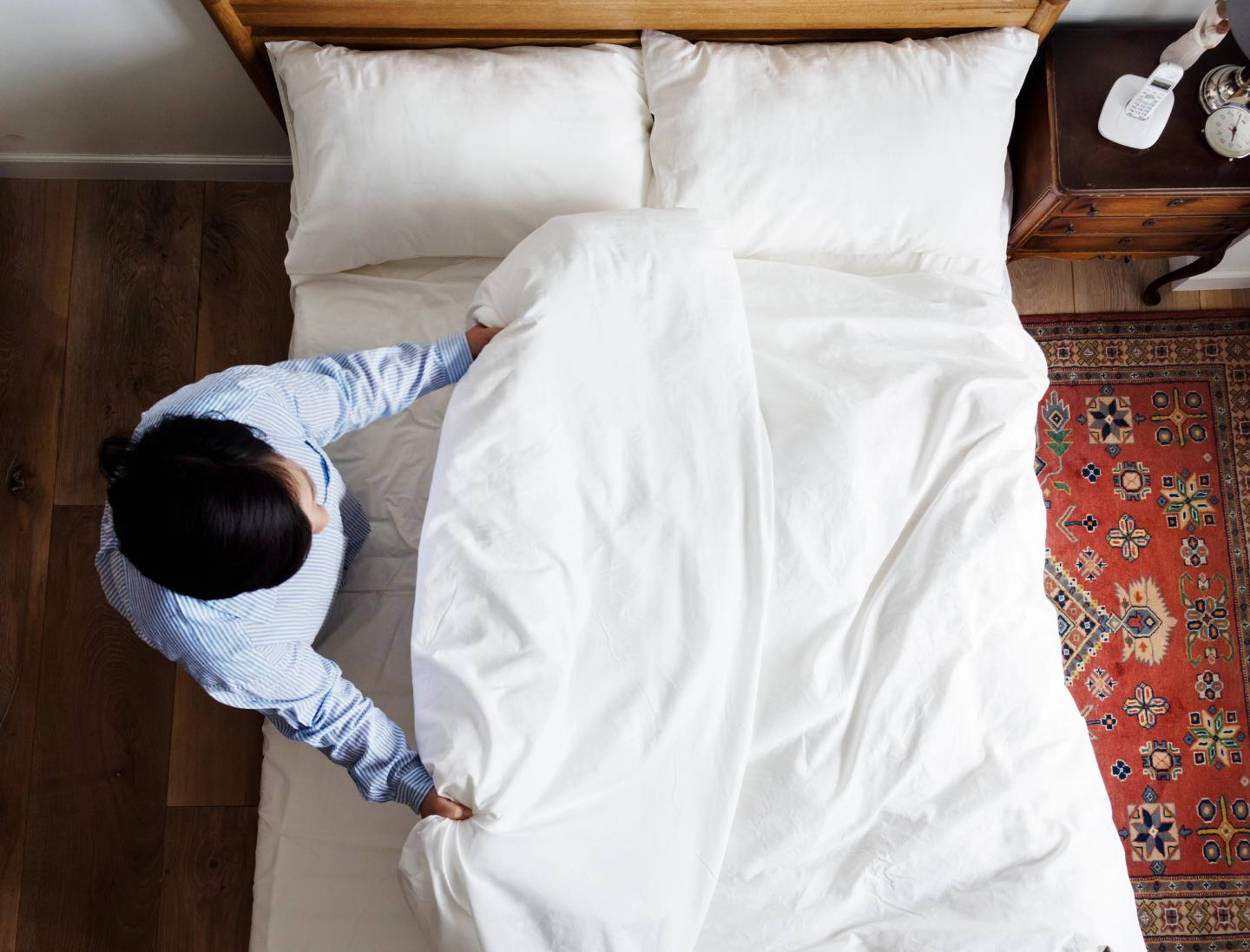 Woman making her bed in the morning.