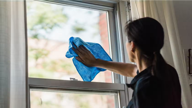 Woman cleaning a window. 