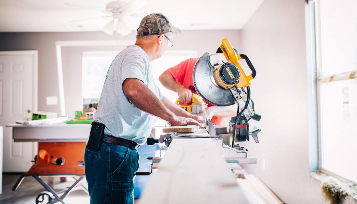 two men using dewalt cutoff saw and jigsaw