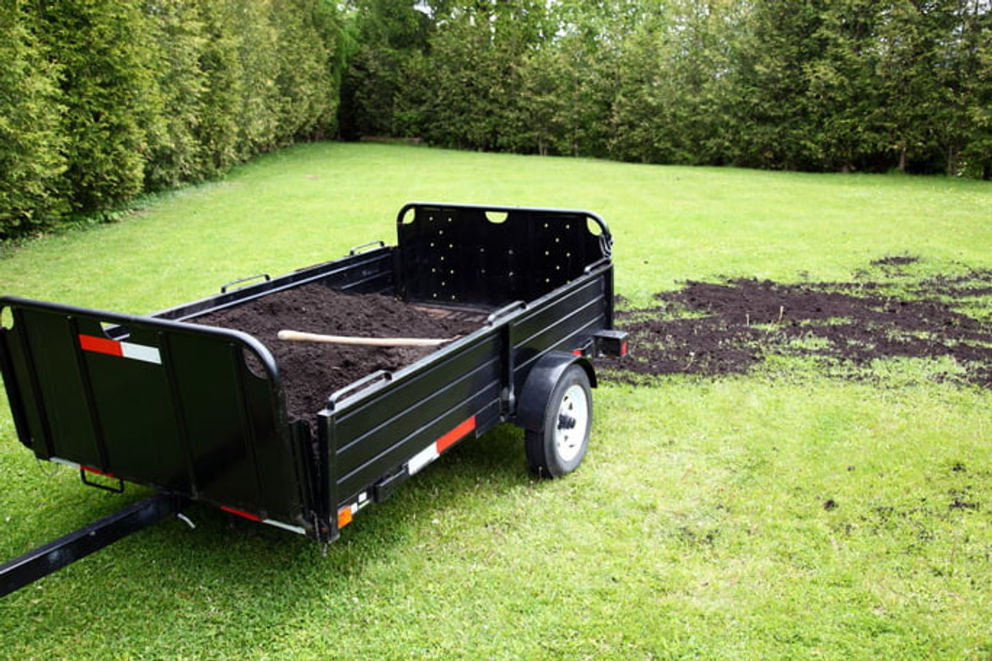 A trailer of soil on the grass lawn