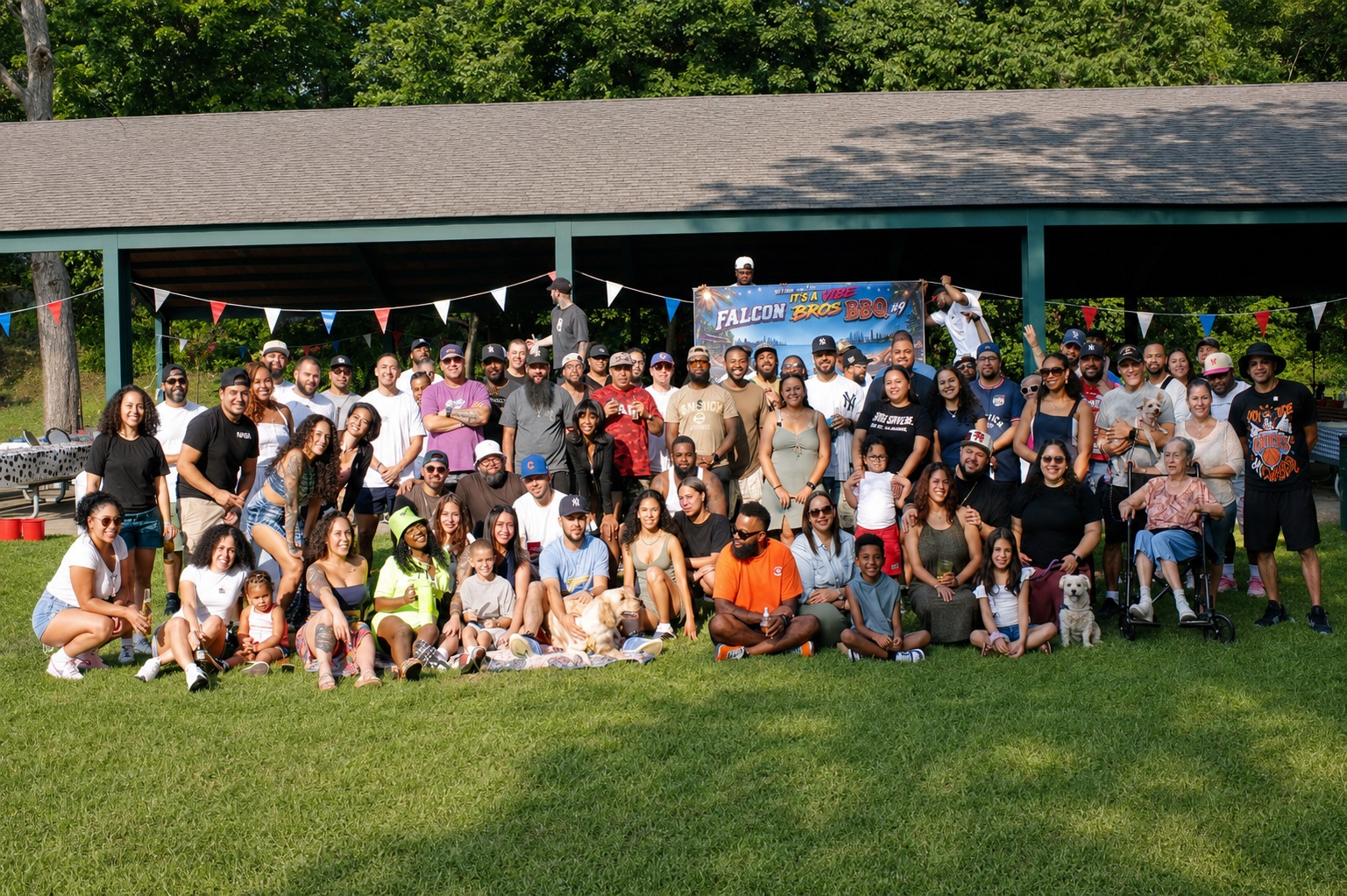 Photo of a large group of people of front of a pavilion with a sign saying "Falcon Bro's BBQ"
