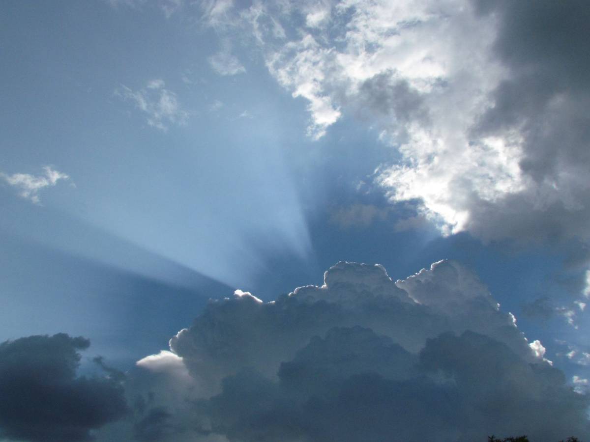 Sonnenstrahlen brechen durch eine aufreißende Wolkendecke