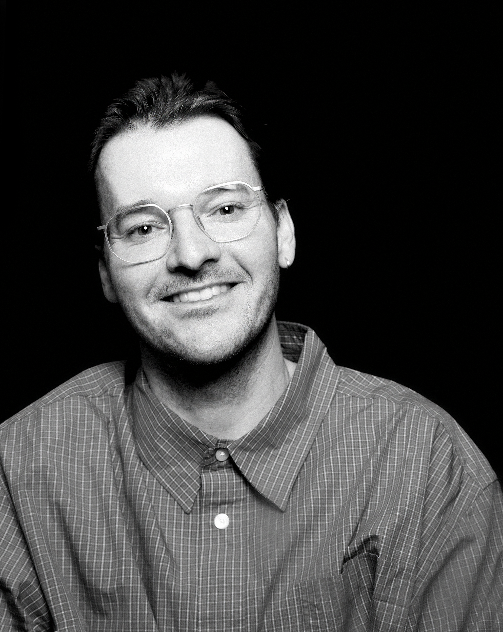 a man with his arms crossed is wearing a black shirt