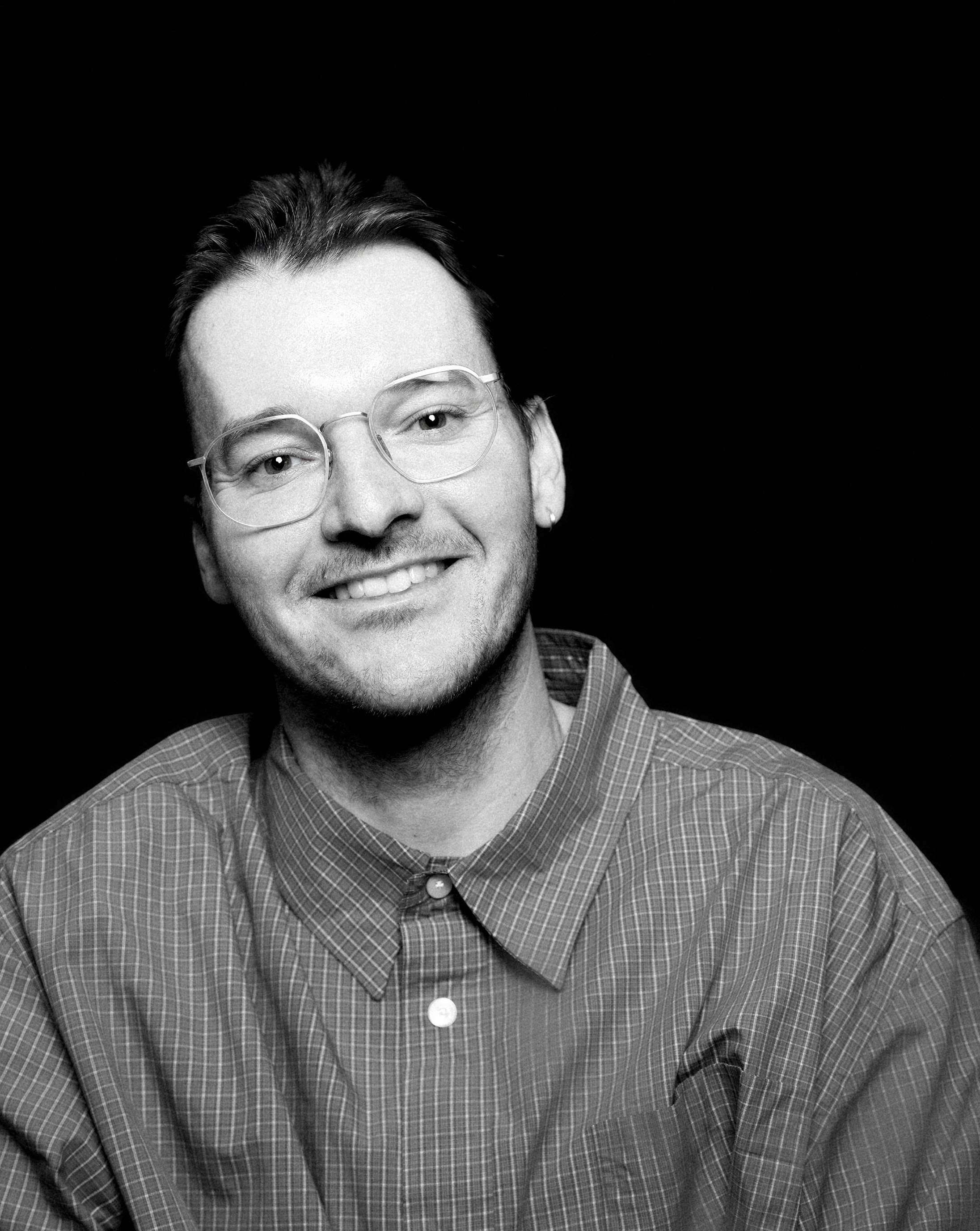 a man with his arms crossed is wearing a black shirt