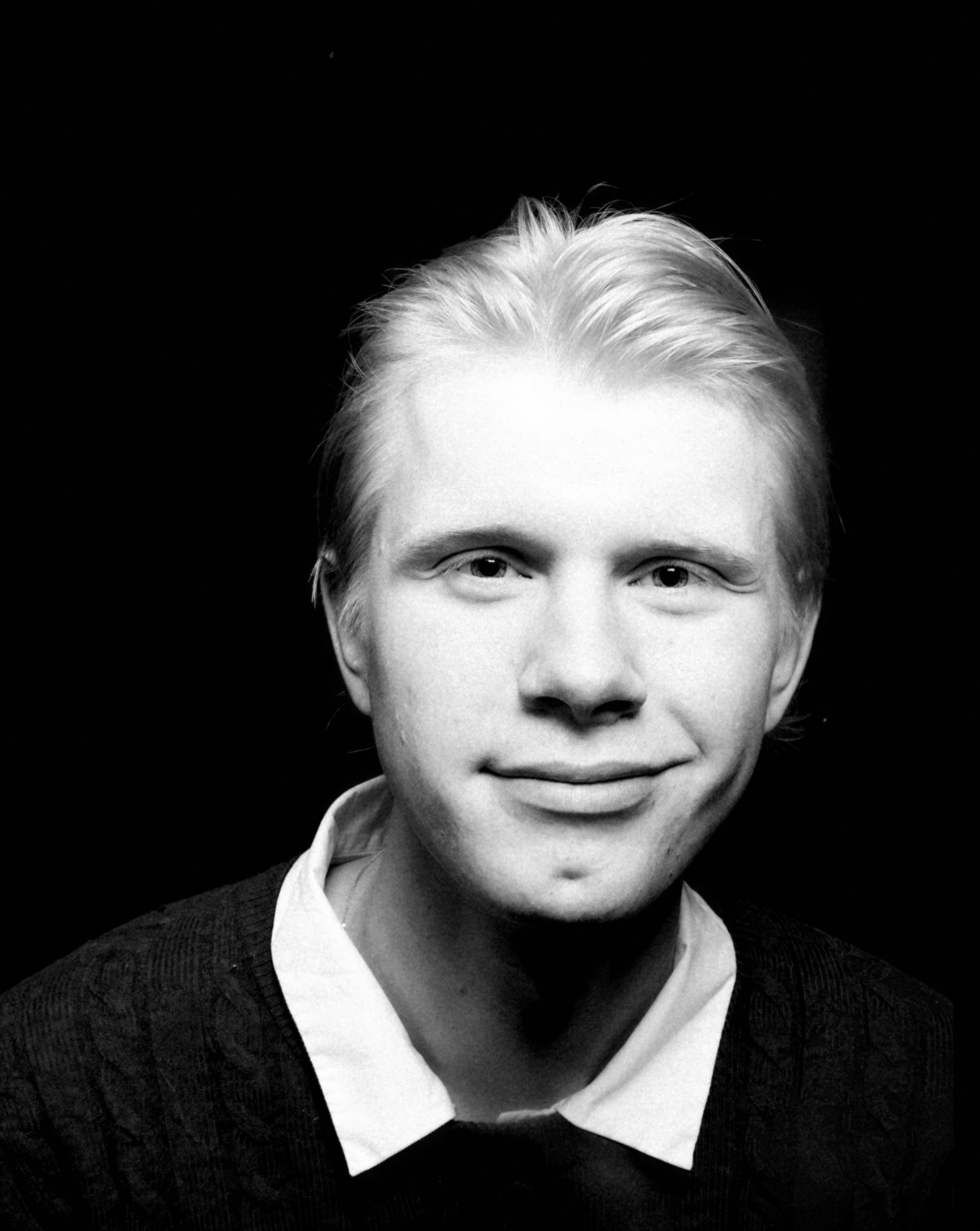 a man with short blond hair wearing a black tee-shirt