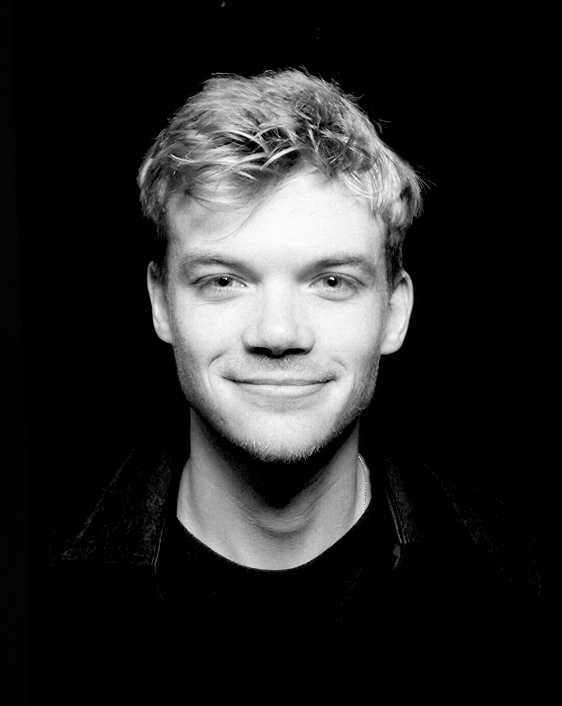 a man with blonde hair wearing a black shirt