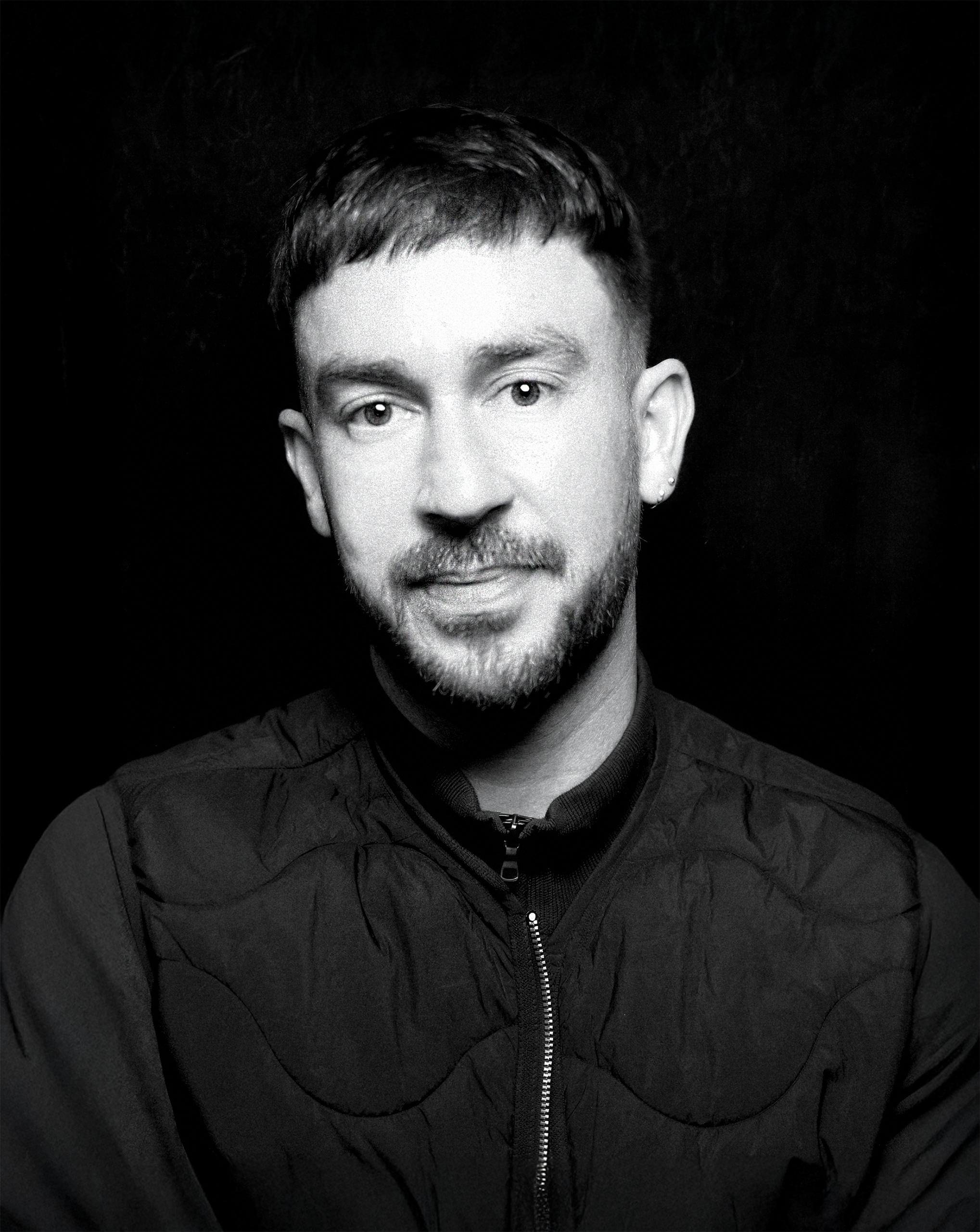 a man with short brown hair wearing a black tee-shirt