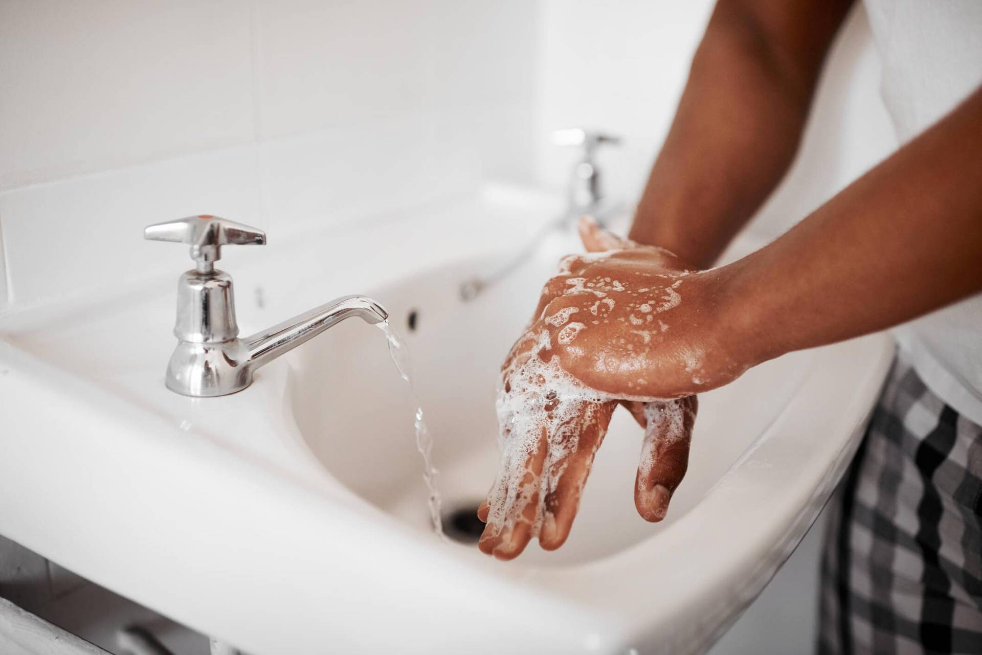 Personne se lavant les mains au lavabo.