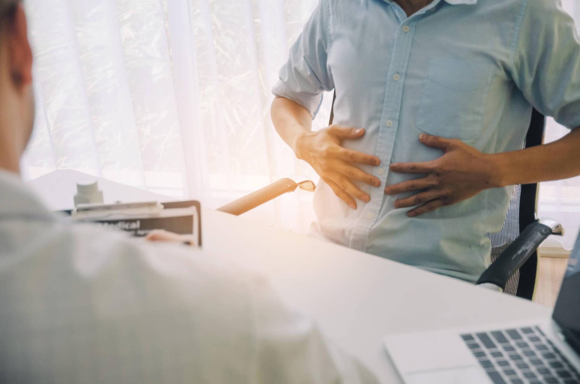 Professionnel de santé examinant le ventre d’un adulte.